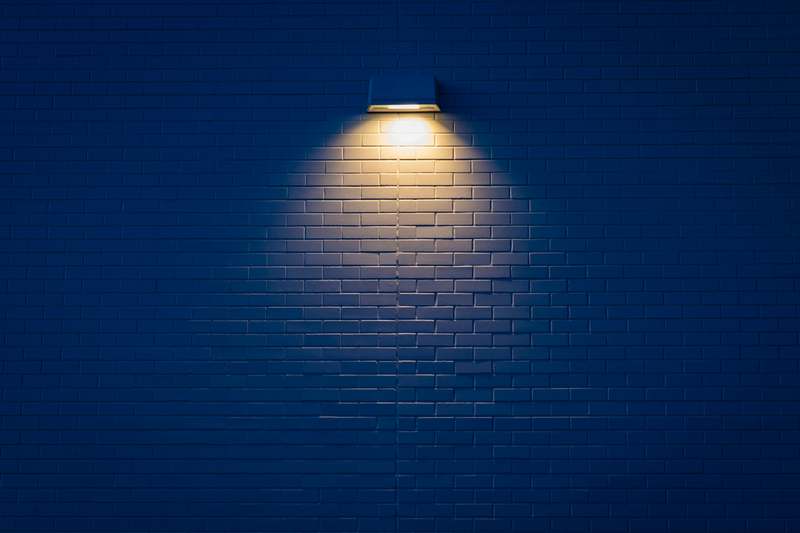 Close-up of adjustable picture lights highlighting framed prints on a neutral wall